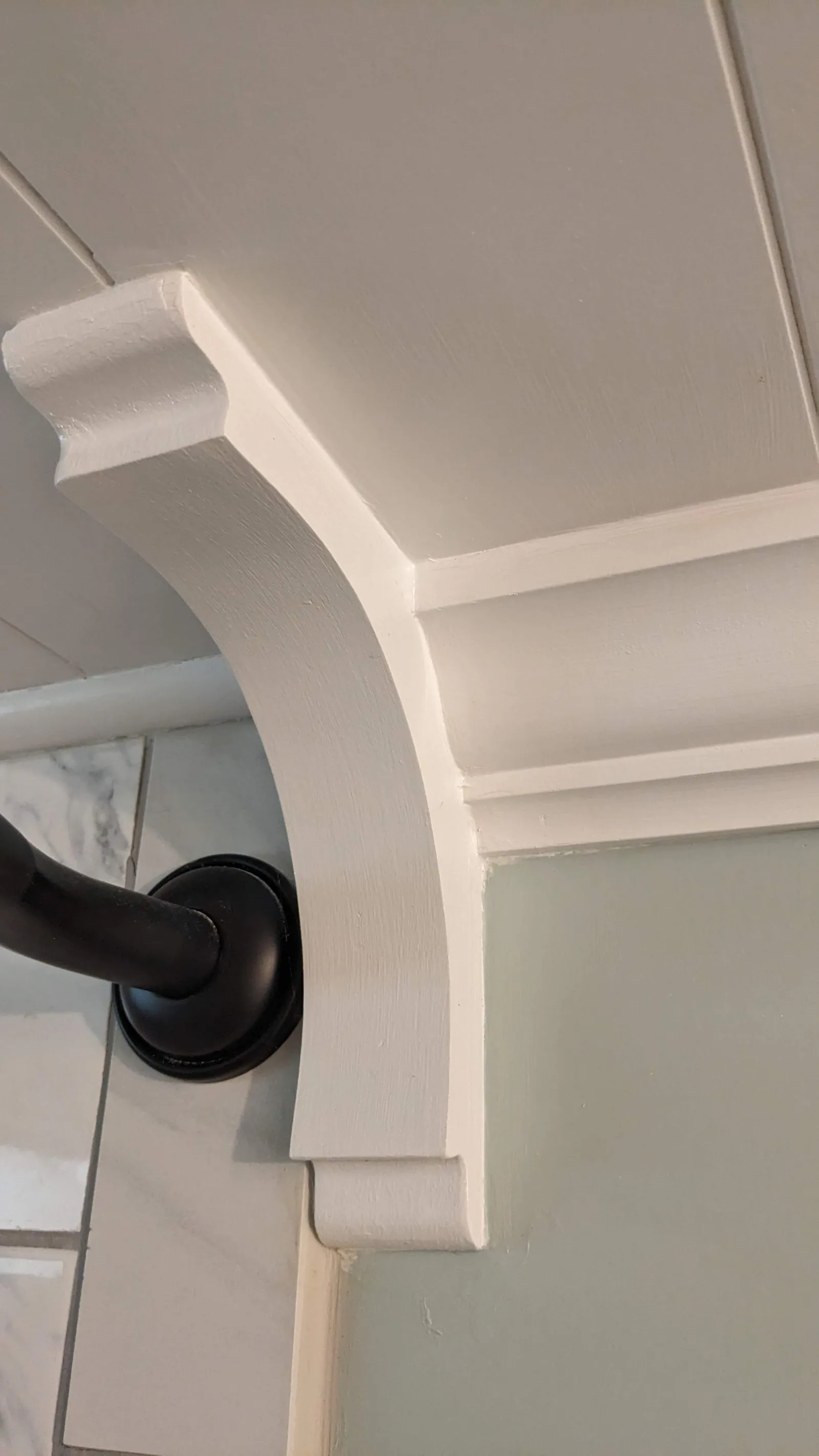 Corbel abutted against bullnose tile, framing the shower area